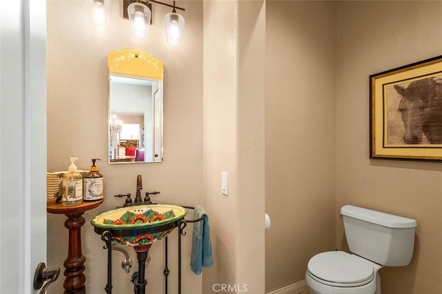 half bathroom with toilet and baseboards