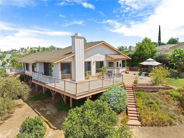 back of property featuring a gazebo and a wooden deck