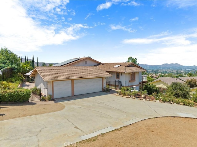 view of front of house with a mountain view, a garage, and solar panels