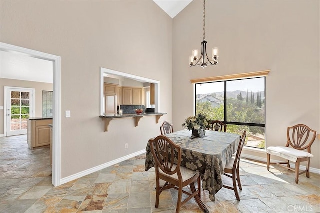 dining space featuring a mountain view, a notable chandelier, and high vaulted ceiling