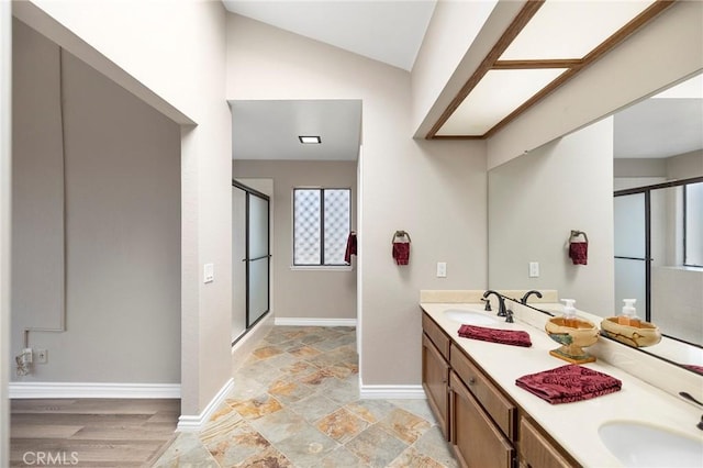 bathroom featuring vaulted ceiling, vanity, and a shower with shower door