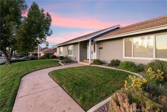 single story home featuring a lawn