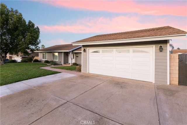 ranch-style home with a garage and a yard