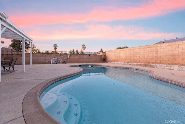 pool at dusk with a patio