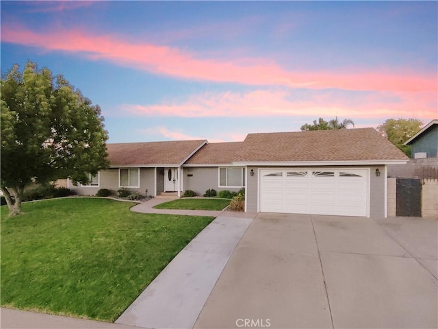 single story home featuring a lawn and a garage