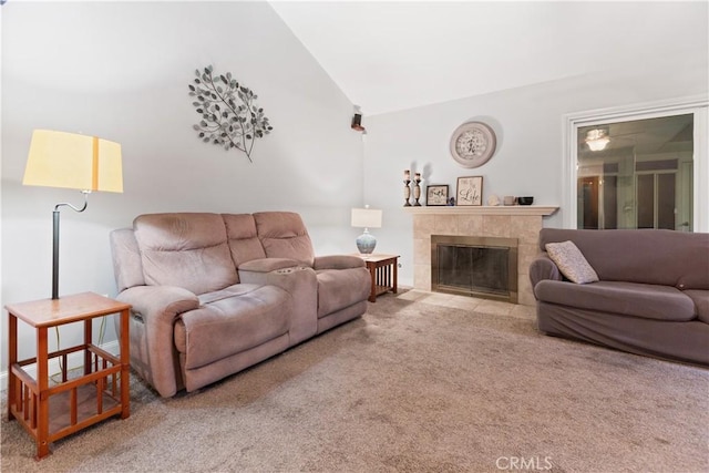 living room featuring light colored carpet, lofted ceiling, and a tiled fireplace