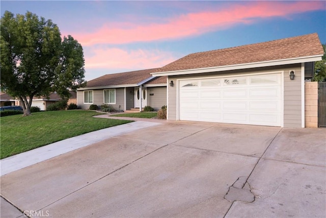 single story home with a lawn and a garage