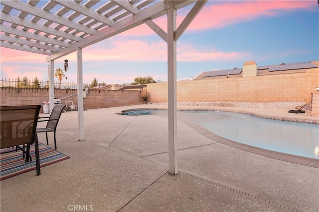 patio terrace at dusk with a pergola and a fenced in pool