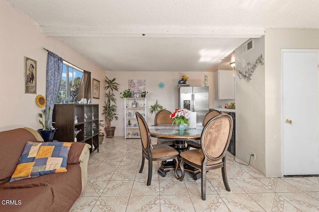 tiled dining area featuring a textured ceiling