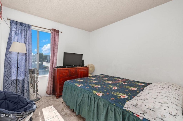 bedroom featuring light tile patterned flooring and a textured ceiling