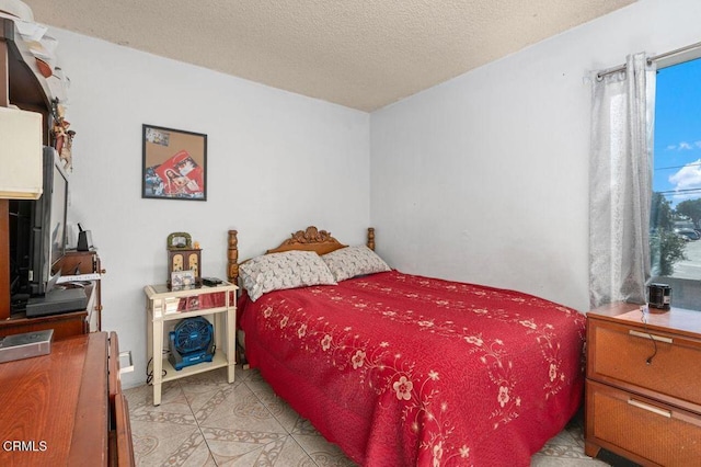 tiled bedroom featuring a textured ceiling