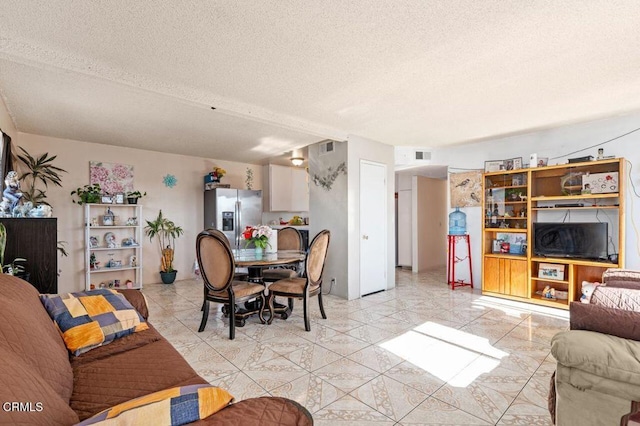 tiled living room featuring a textured ceiling