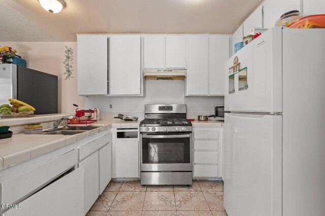 1431 Casa San Carlos Ln Unit A, Oxnard, CA 93033 - kitchen featuring appliances with stainless steel finishes, under cabinet range hood, tile counters, and white cabinetry