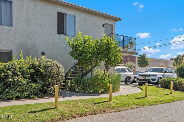 1431 Casa San Carlos Ln Unit A, Oxnard, CA 93033 - view of property exterior with a yard, stucco siding, and a balcony