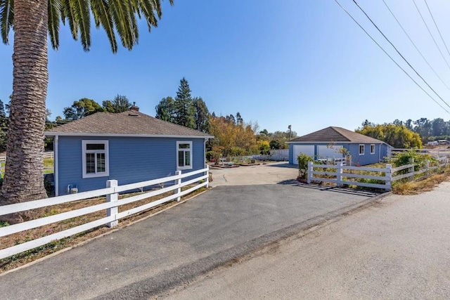 view of front of home featuring a garage and an outbuilding