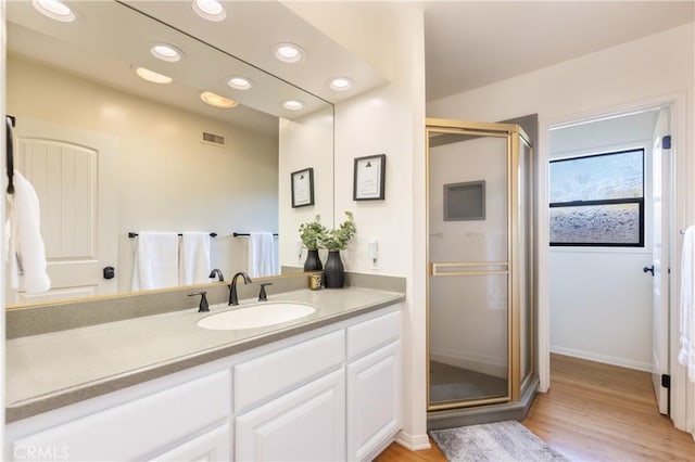 bathroom featuring vanity, wood-type flooring, and a shower with door