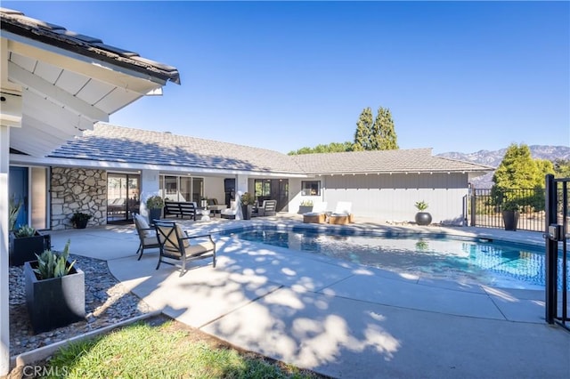 view of swimming pool featuring outdoor lounge area, a mountain view, and a patio area