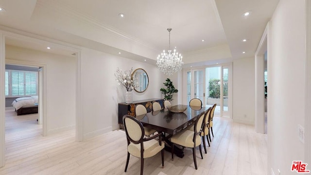 dining area featuring a notable chandelier, light hardwood / wood-style floors, crown molding, and a tray ceiling