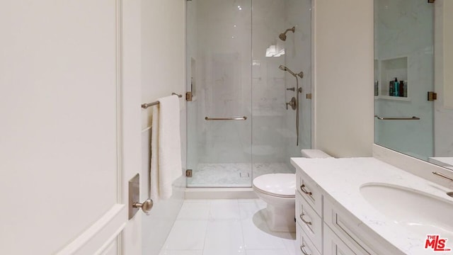 bathroom featuring tile patterned floors, vanity, toilet, and a shower with door