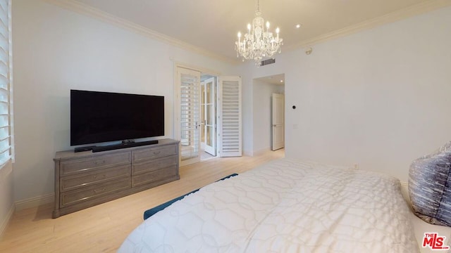 bedroom featuring light hardwood / wood-style floors, an inviting chandelier, and ornamental molding