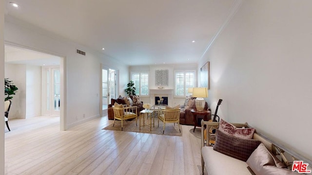 living room with crown molding and light wood-type flooring