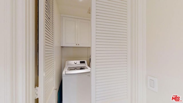 clothes washing area with cabinets and washer / dryer