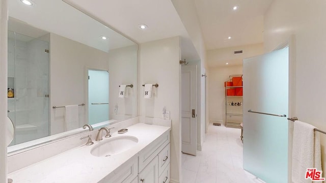 bathroom with vanity and a shower with shower door