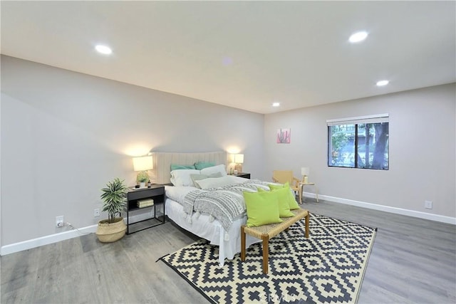 bedroom with baseboards, wood finished floors, and recessed lighting