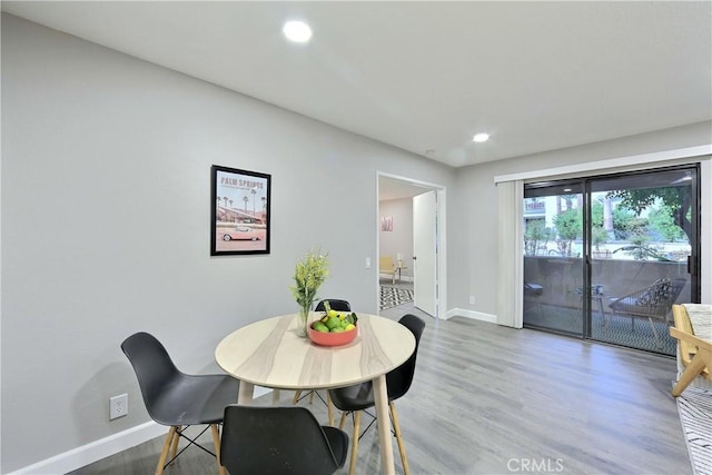 dining room with baseboards, wood finished floors, and recessed lighting