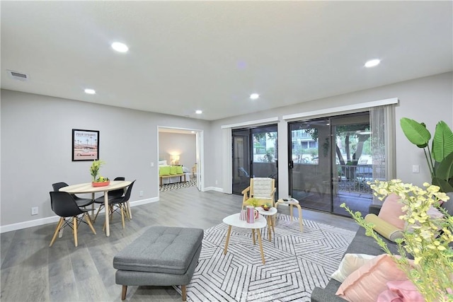 living room featuring baseboards, wood finished floors, visible vents, and recessed lighting