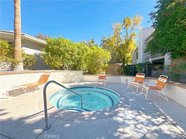 view of pool with a hot tub, fence, and a patio