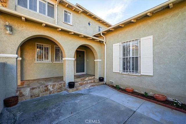 view of exterior entry with a patio area