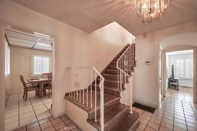 staircase with tile patterned flooring and a chandelier