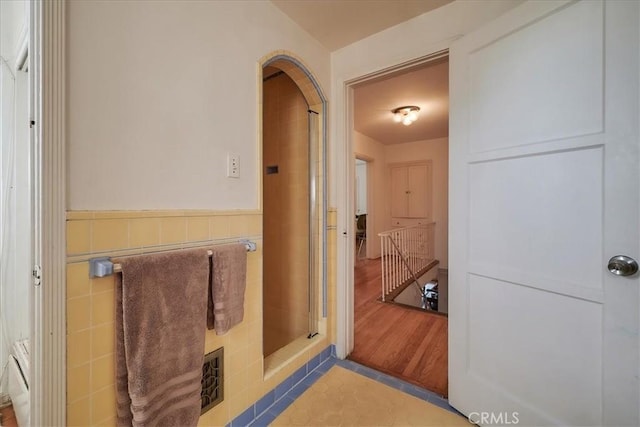 interior space with hardwood / wood-style floors and tile walls