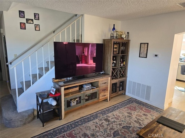 living room featuring a textured ceiling and hardwood / wood-style flooring