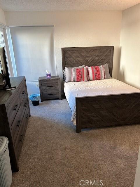 carpeted bedroom featuring a textured ceiling