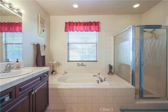 bathroom featuring plus walk in shower, plenty of natural light, and vanity