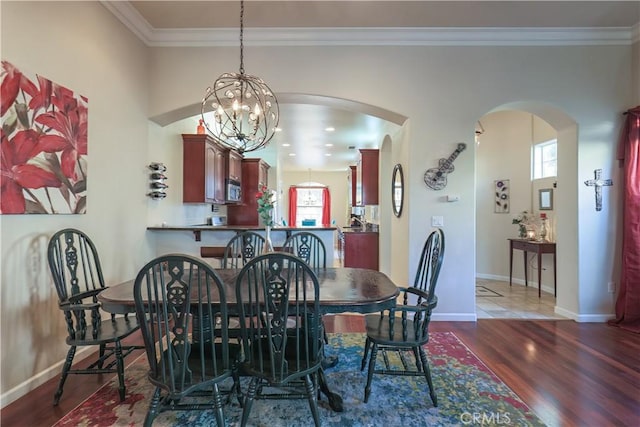 dining area with plenty of natural light, ornamental molding, and dark wood-type flooring