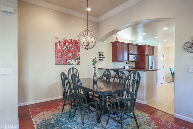 dining area featuring light hardwood / wood-style floors, an inviting chandelier, and ornamental molding