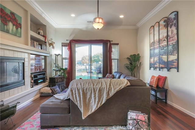 living room with built in shelves, dark hardwood / wood-style flooring, and crown molding