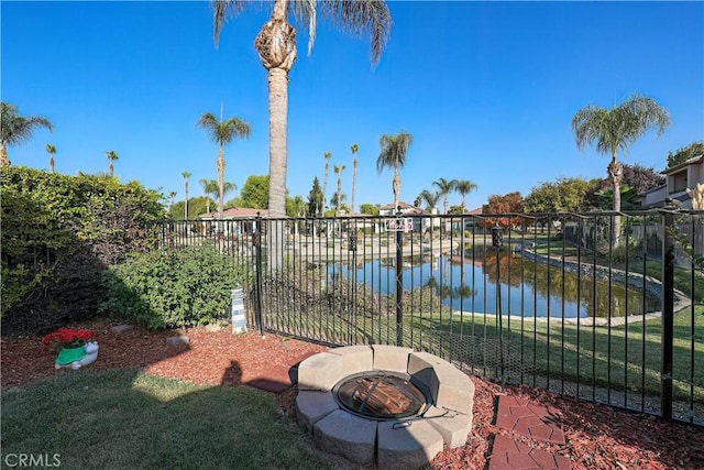 exterior space with a water view and an outdoor fire pit