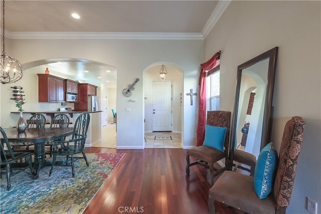 dining space featuring an inviting chandelier, light hardwood / wood-style floors, and ornamental molding