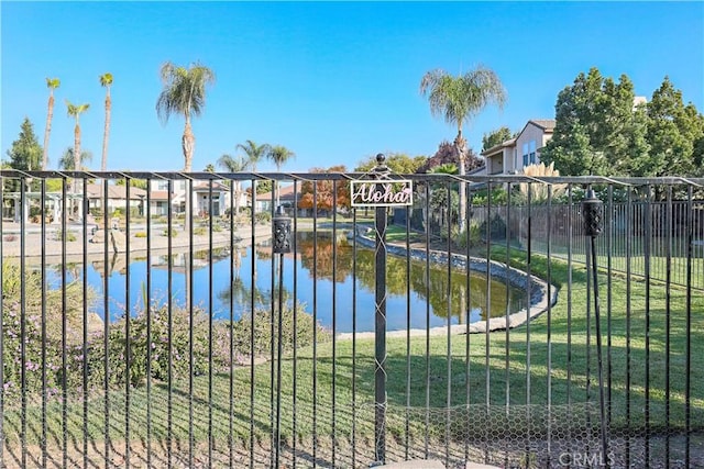 view of gate featuring a yard and a water view