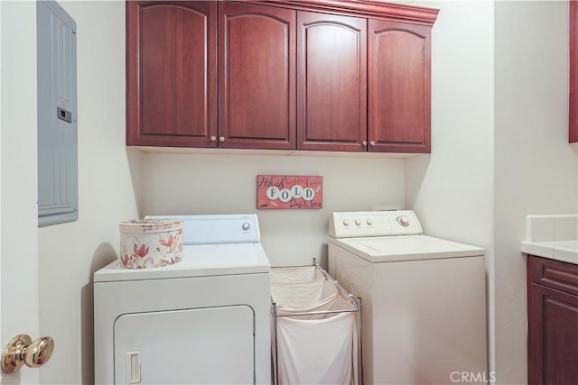 laundry room with cabinets, electric panel, and washing machine and clothes dryer