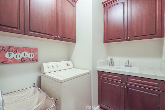 laundry area with sink, cabinets, and washer / dryer