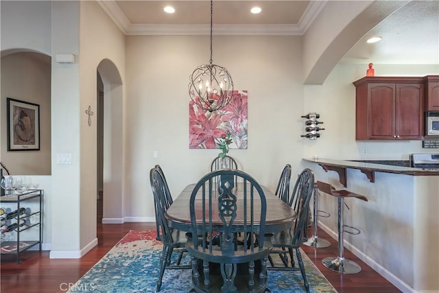 dining room with ornamental molding, dark hardwood / wood-style floors, and a notable chandelier