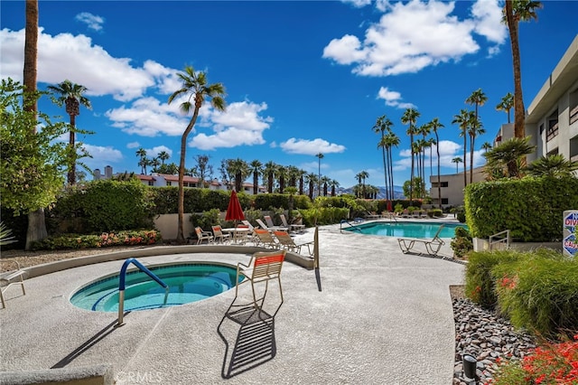 view of pool with a patio and a hot tub