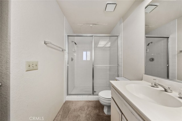 bathroom with vanity, toilet, and a shower with door