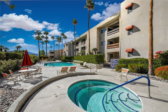 view of swimming pool with a community hot tub and a patio