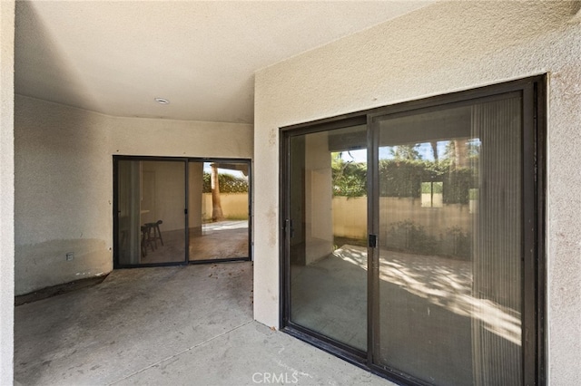 view of exterior entry with a patio area